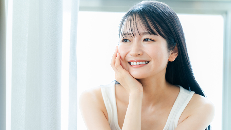 輝く笑顔で頬に手を添